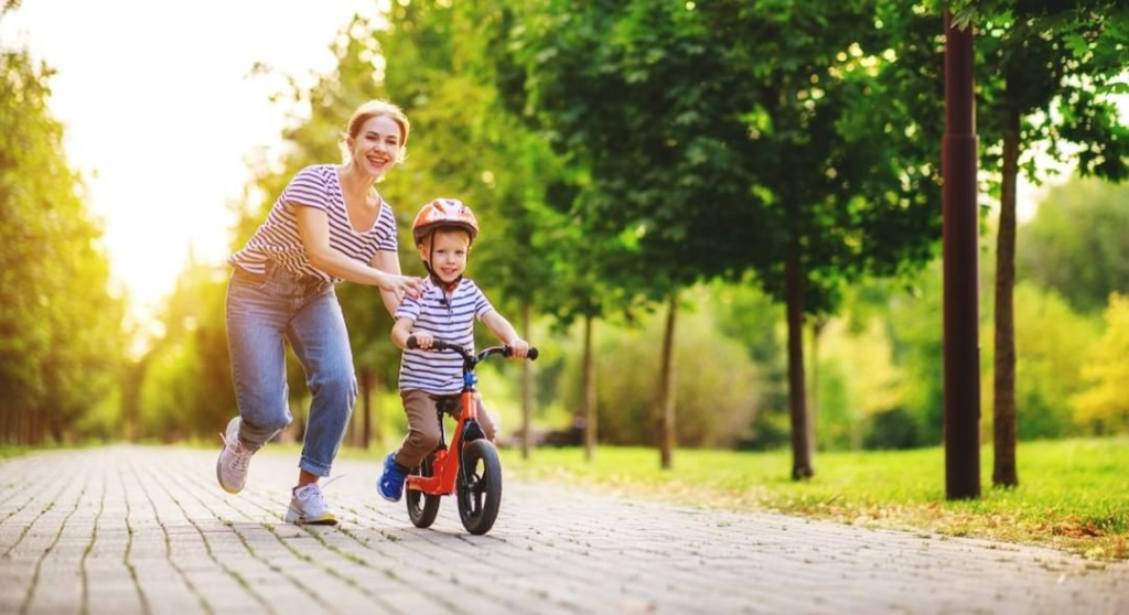 mom helping son on balance bike