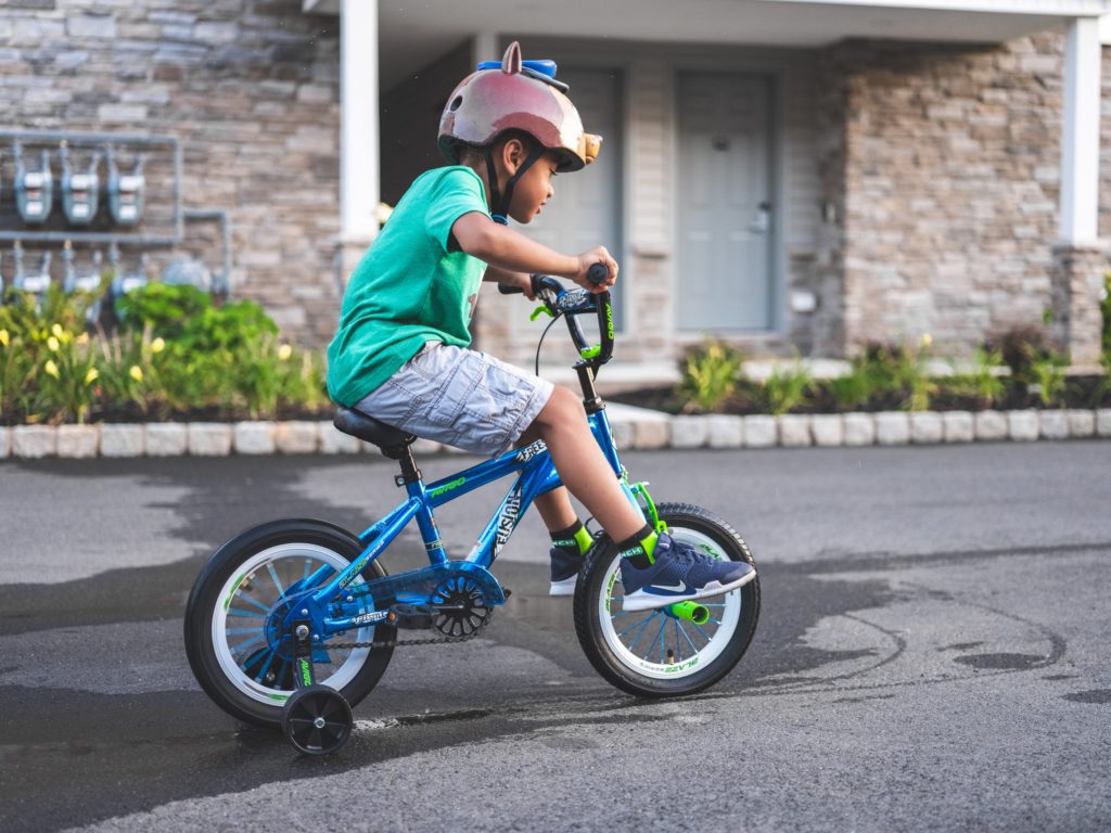 kid with training wheels on his bike