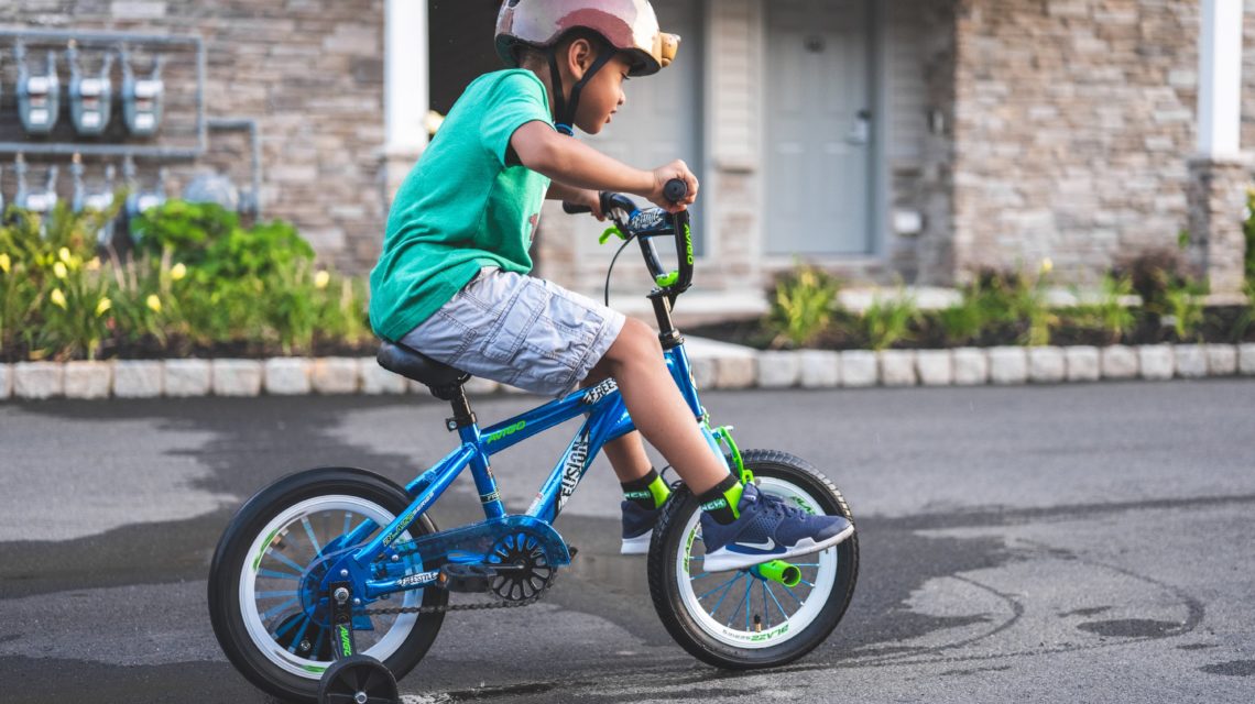 kid with training wheels on his bike